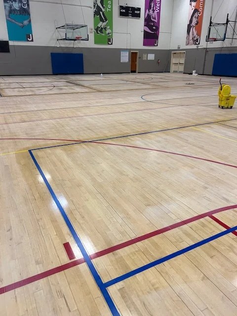 Worn gymnasium wood floor before refinishing in Portland