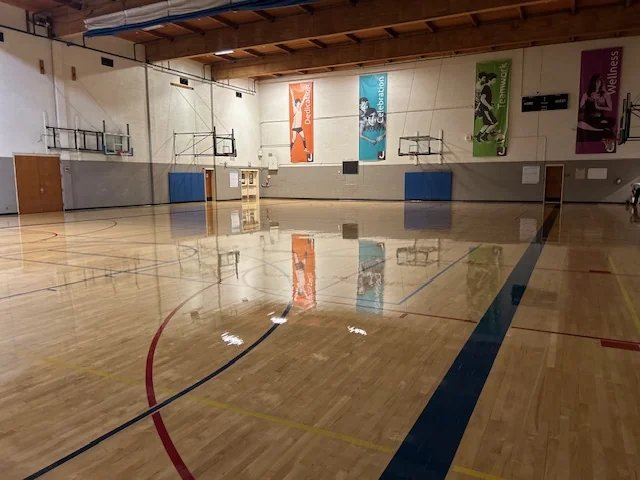 Gymnasium floor after refinishing — mirror gloss and crisp game lines